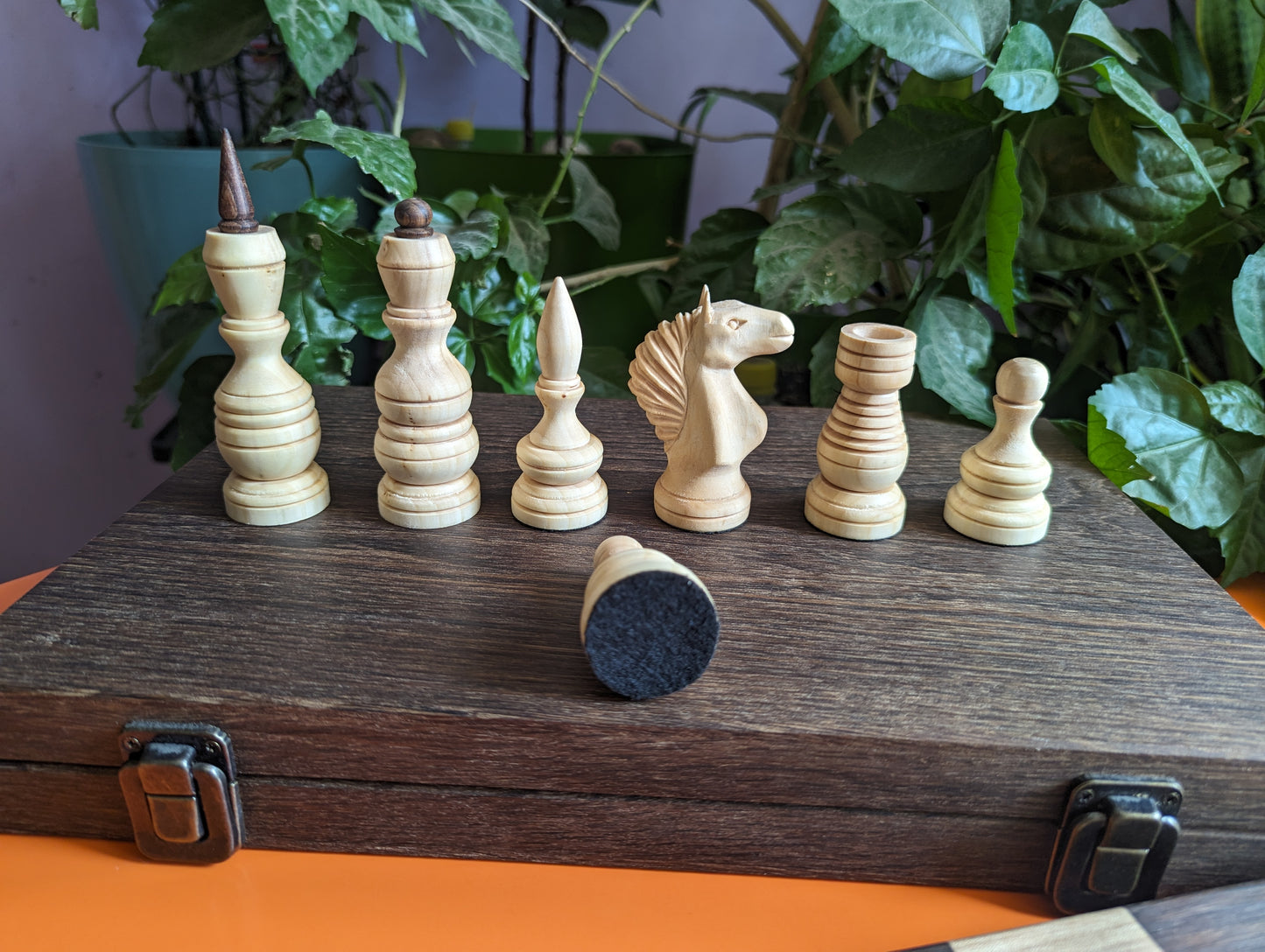 Handcrafted wooden carved chess pieces. White maple and walnut wood.
